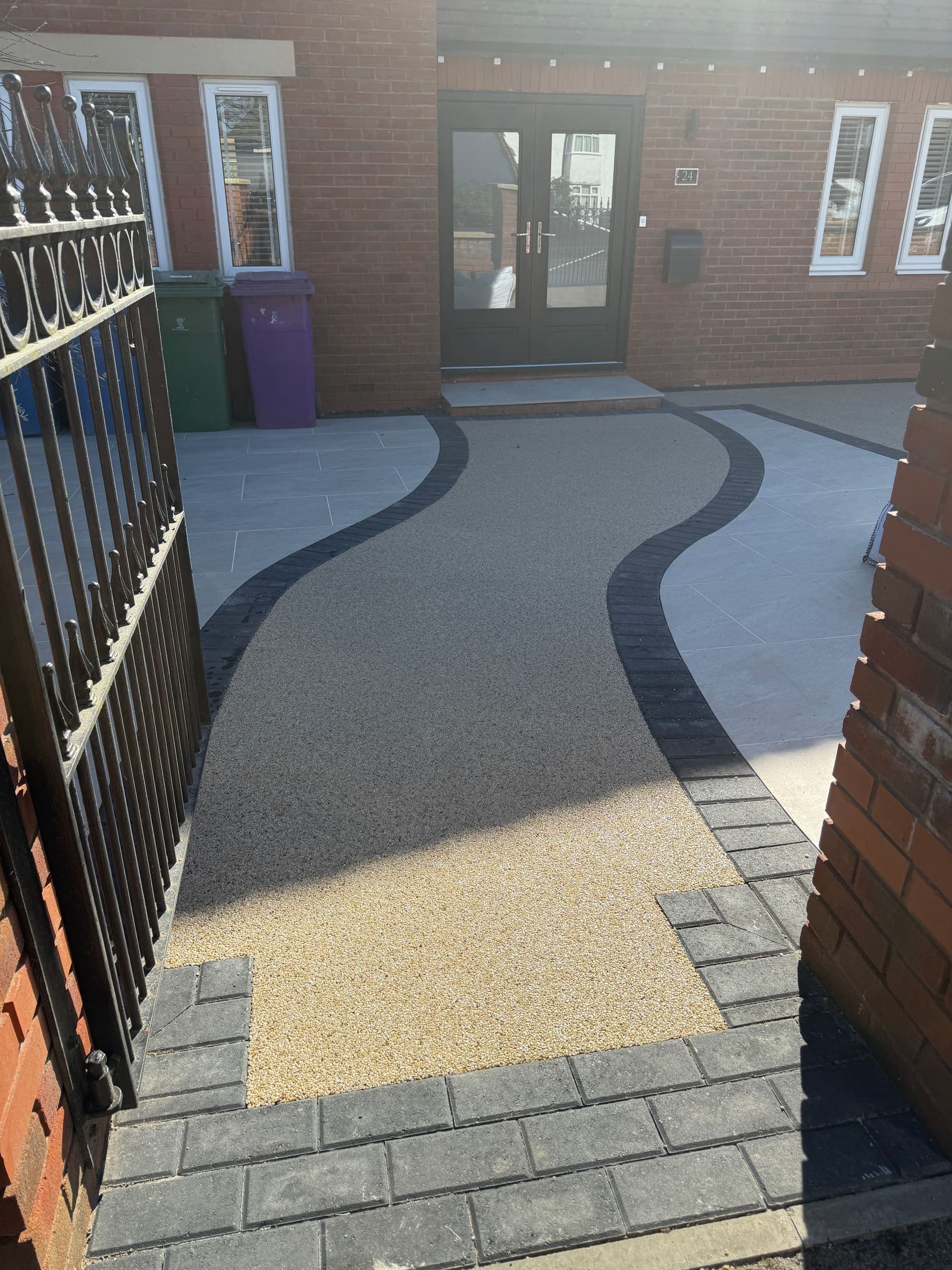 Decorative resin driveway with a curved design and block paving border in Liverpool