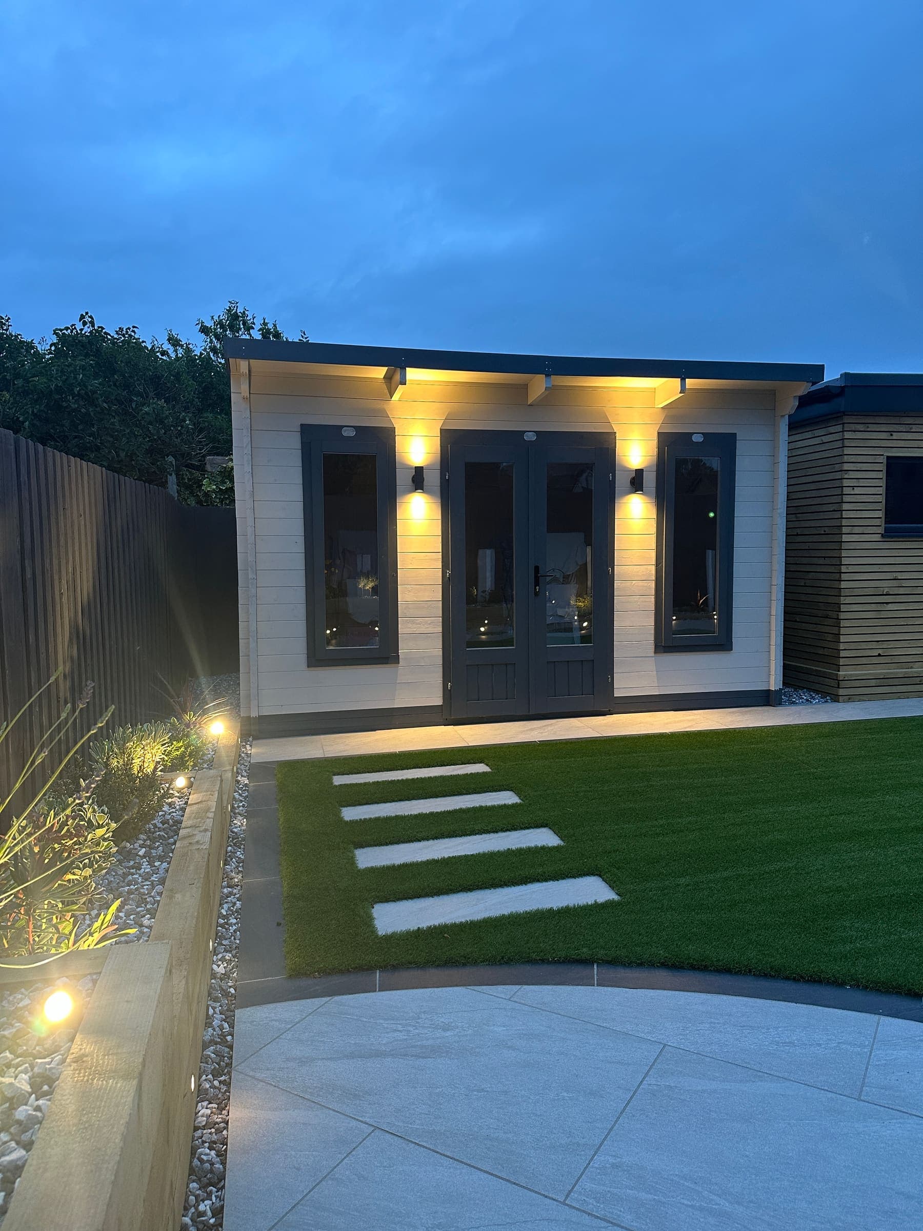Modern insulated garden room with decking and exterior lighting in a Liverpool garden