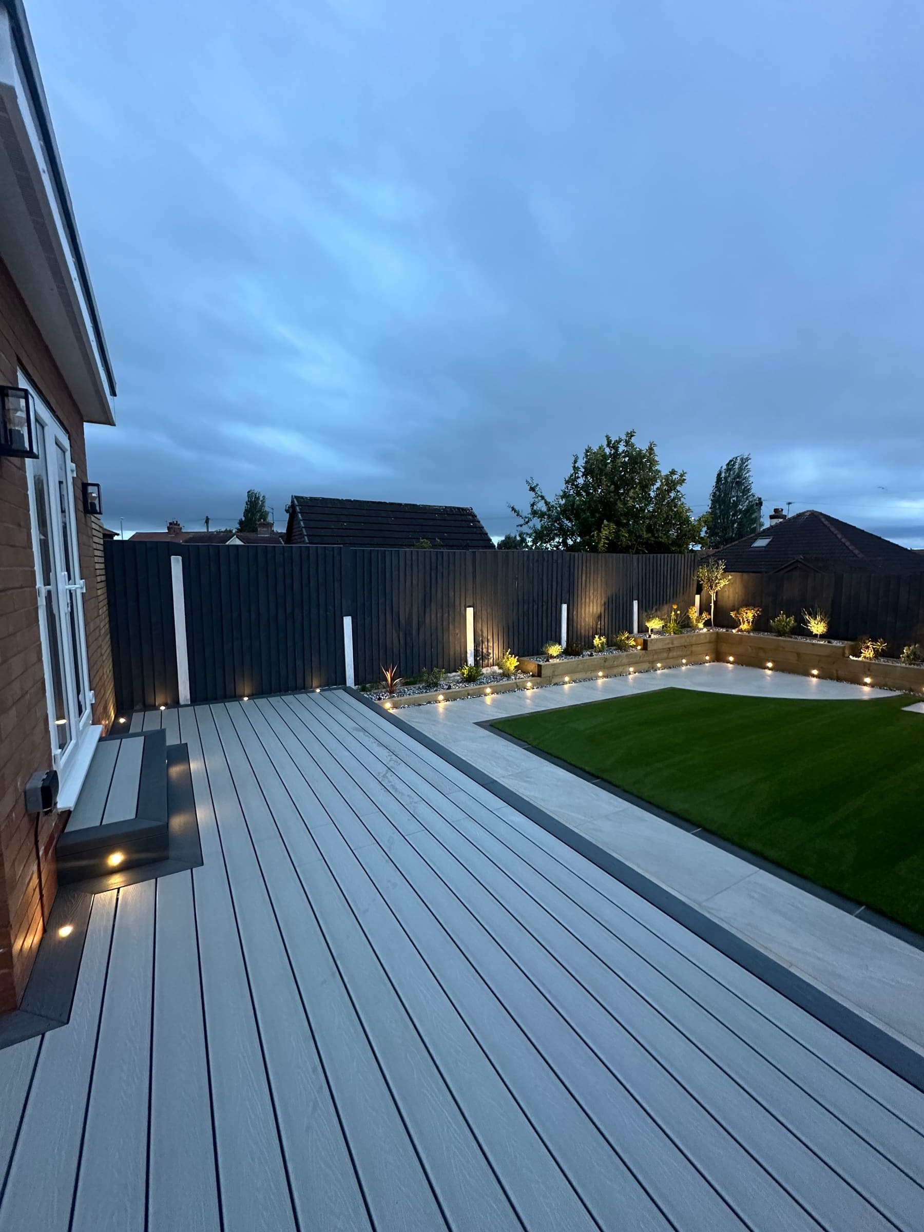 Modern raised patio with artificial grass in a Liverpool garden