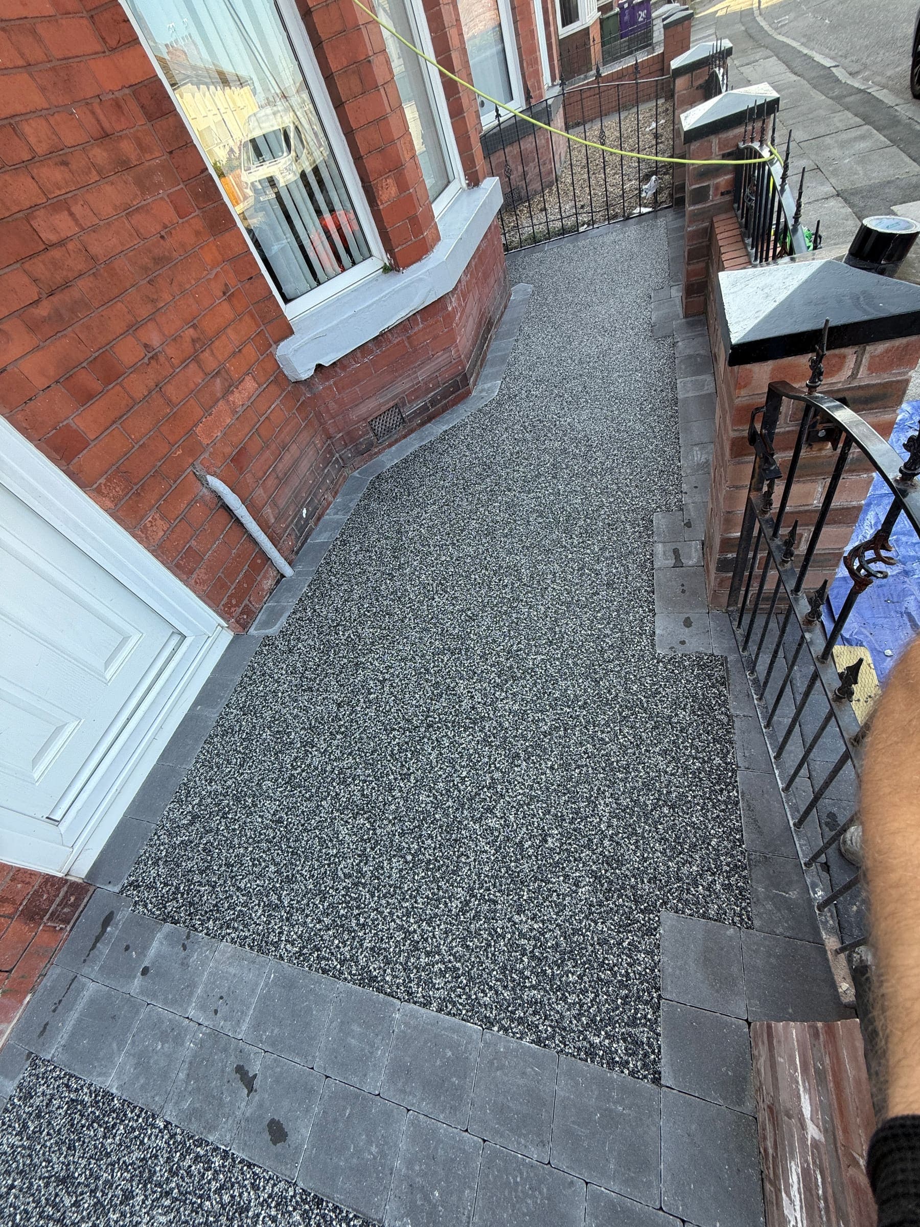 Narrow resin driveway and side pathway beside a Liverpool brick house