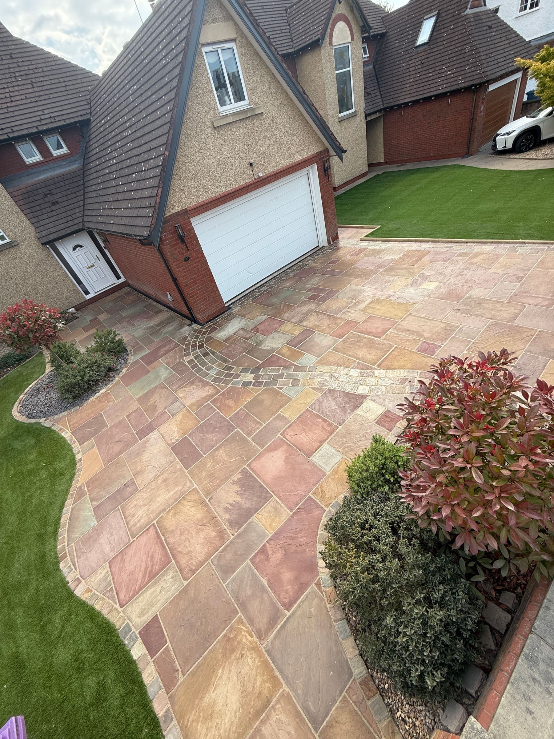 Natural stone driveway with decorative borders and garage access in Liverpool