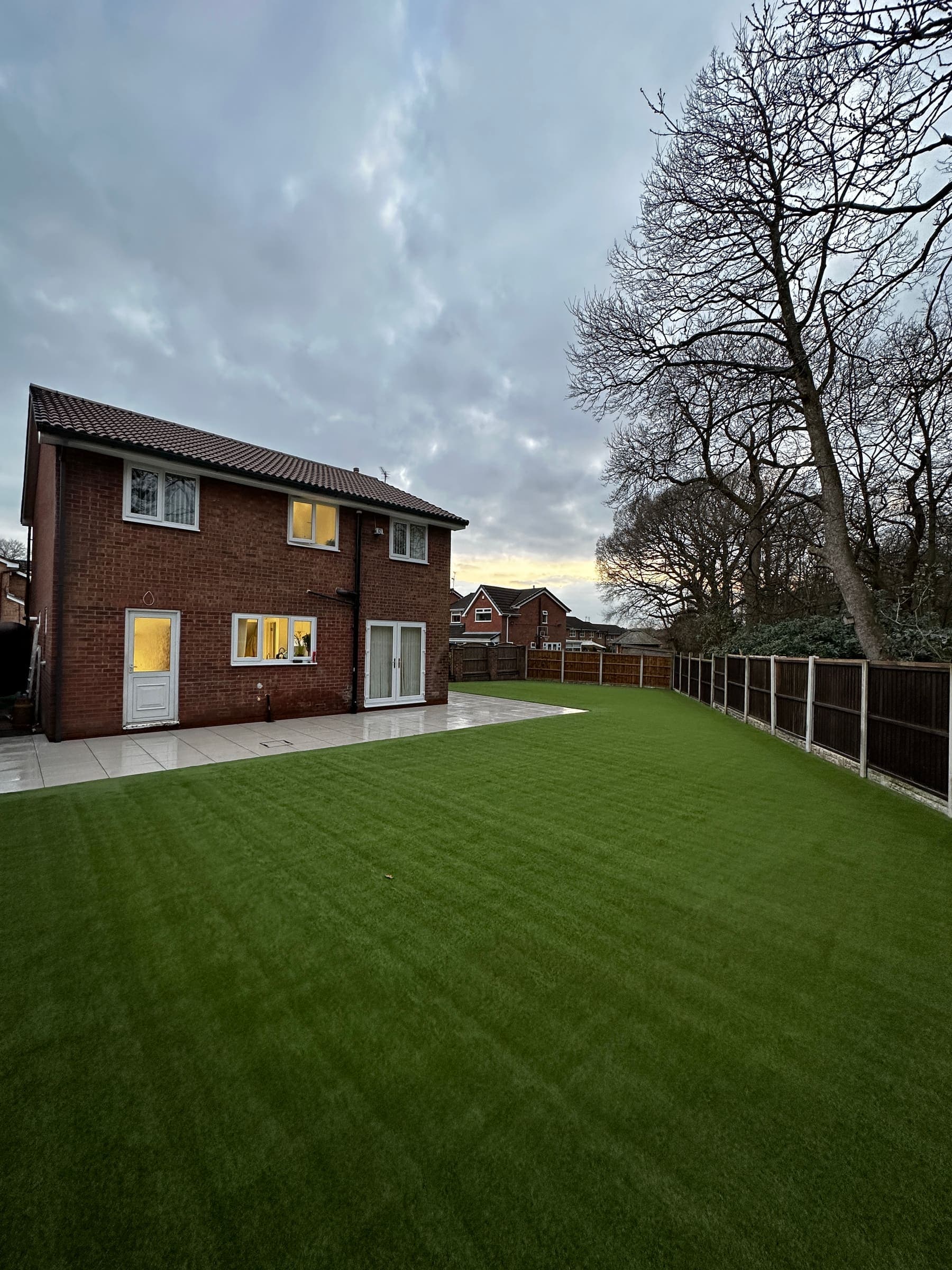New turf installation in a Liverpool back garden with freshly laid grass and a patio