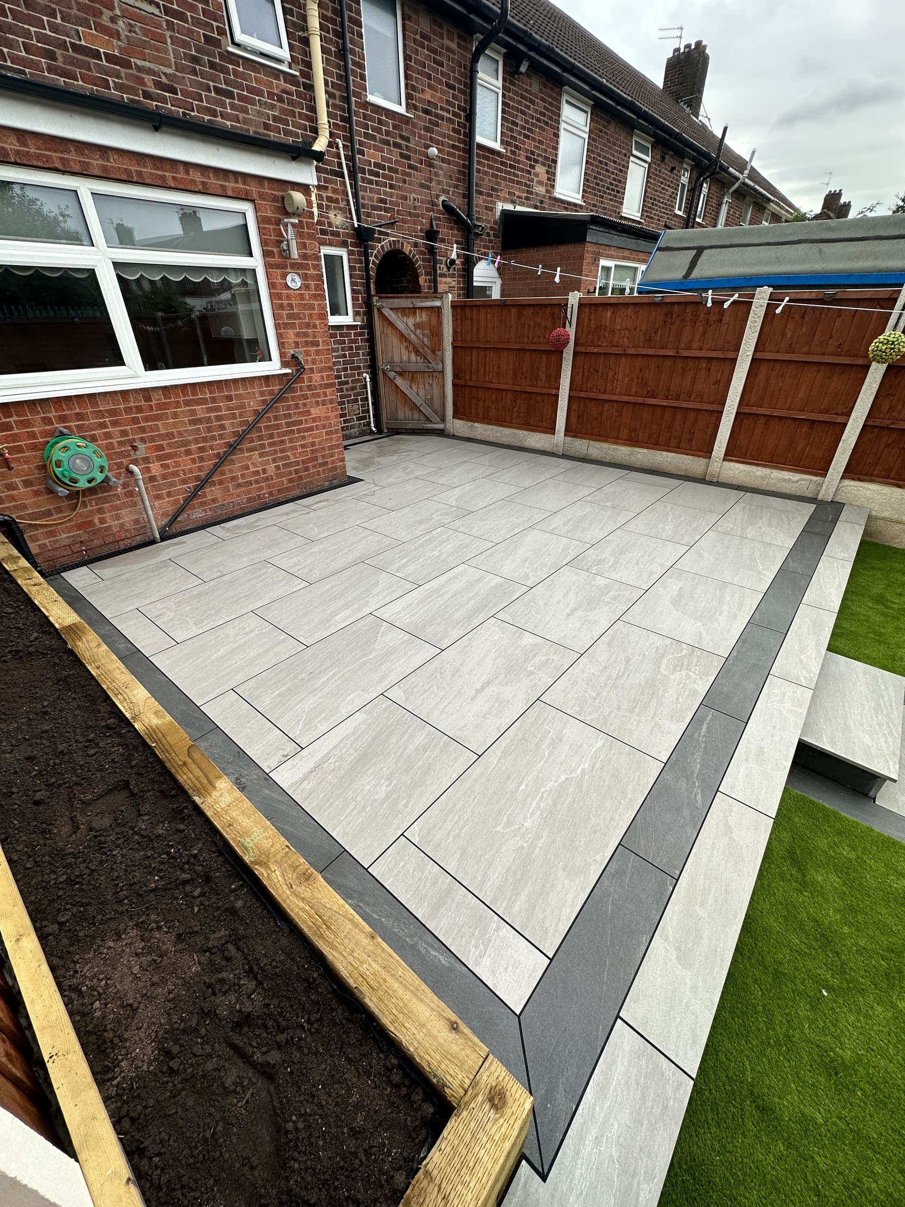 Raised patio installation with artificial grass in a Liverpool garden